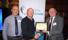 Cllr Brian Johnson presents the award to rowing club members